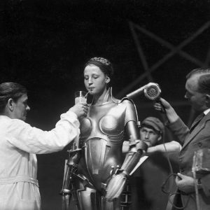 100 2025 02 16 02+on+the+set+of+fritz+lang’s+metropolis+—+the+actress+inside+the+maria+robot+taking+a+breather